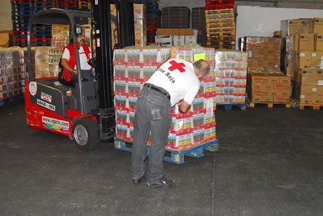 Personas voluntarias en almacen de reparto de alimentos de Cruz roja