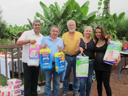 El sacerdote Juan Carlos González, el presidente de los rotarios, Juan Barrientos y el secretario, Fernando Jové, entregando los pañales para la asociación