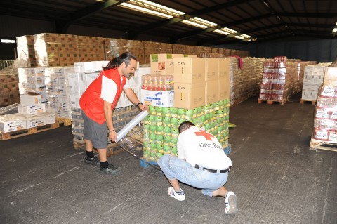 Voluntarios de cruz Roja preparando un envió de alimentos