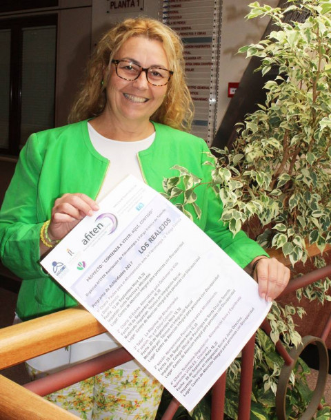 Sandra Pérez Portando el cartel con el programa de charlas y talleres. 