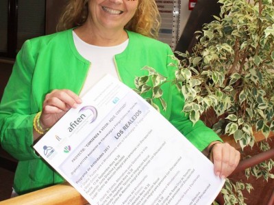 Sandra Pérez Portando el cartel con el programa de charlas y talleres. 